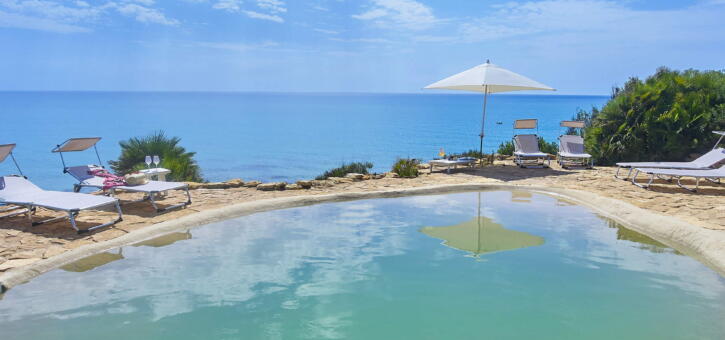A stunning villa with a pool overlooking the crystal-clear sea.